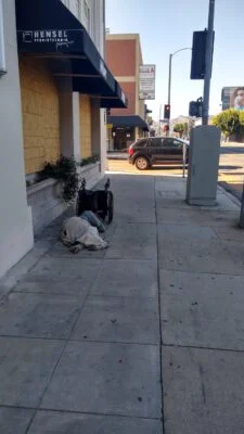 Homeless sleeping next to the street.