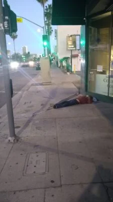Homeless sleeping next to a traffic lights