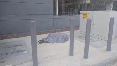 Homeless sleeping next to the street